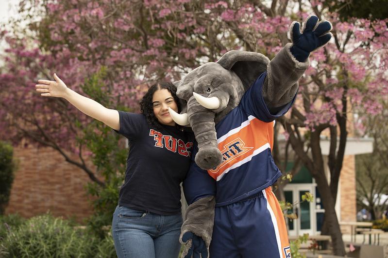 Student and Tuffy pose for a picture